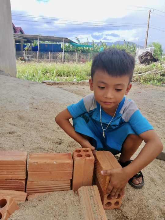 Dat builds a sand bridge with bricks and sand in front of his home in southern Vietnam.