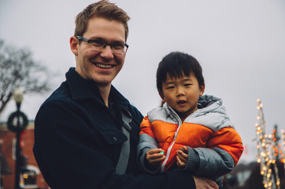 An adoptive dad holds his little boy.