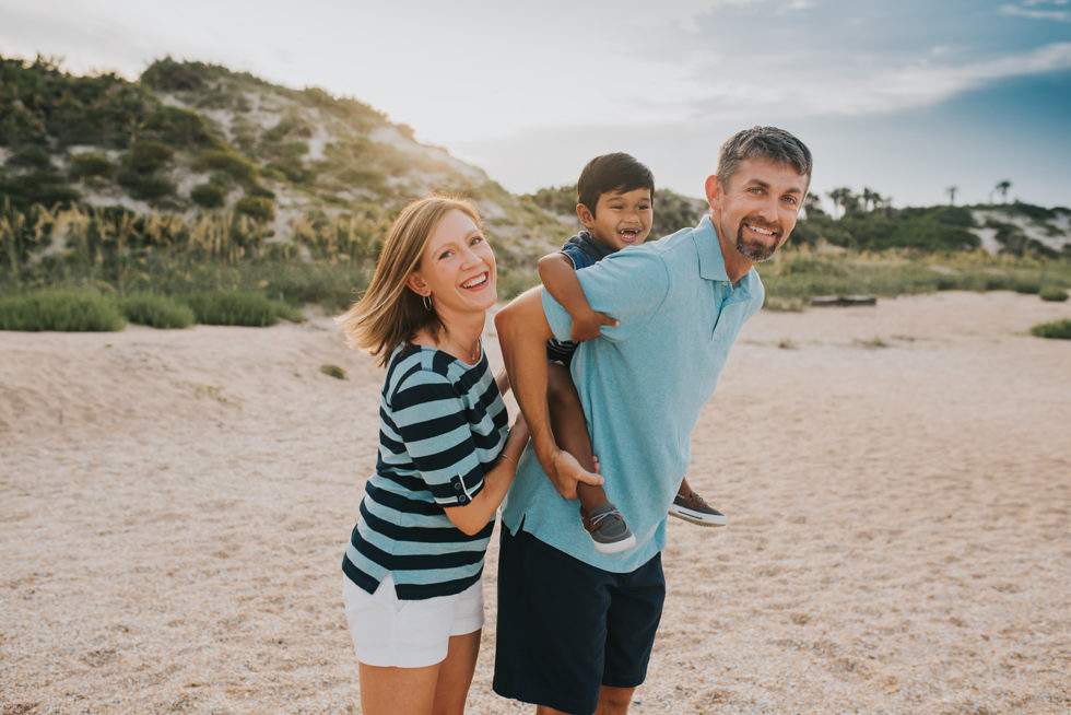 A young boy smiles with his adoptive parents.