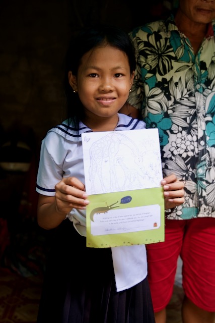 Linna holds a birthday card from her sponsor.