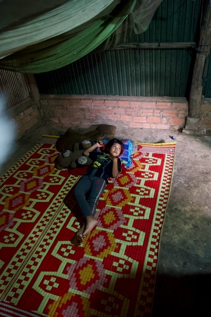 The whole family sleeps together on a woven floor mat — under a single mosquito net. They are scared of snakes, and of scorpions, which also live in the jungle surrounding their home.