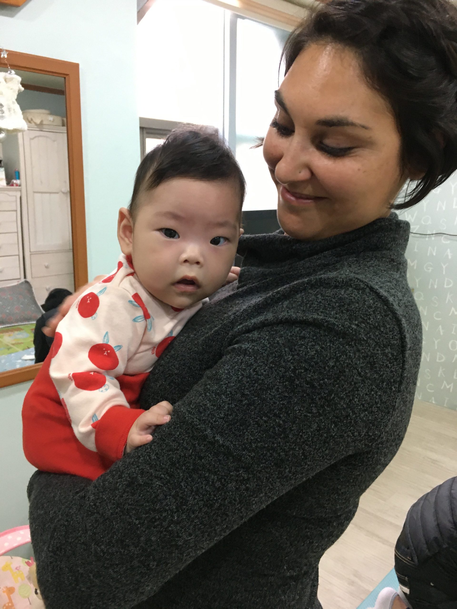 Holt staff member Amanda Baca holds a child in care during the 2019 Korea Gift Team trip. 