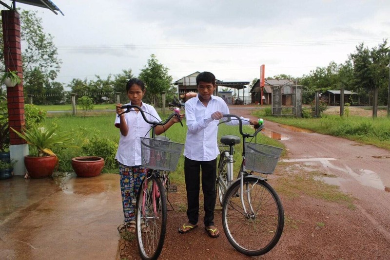 Phal and her twin brother with their new bicycles, which help them safely get to and from school.