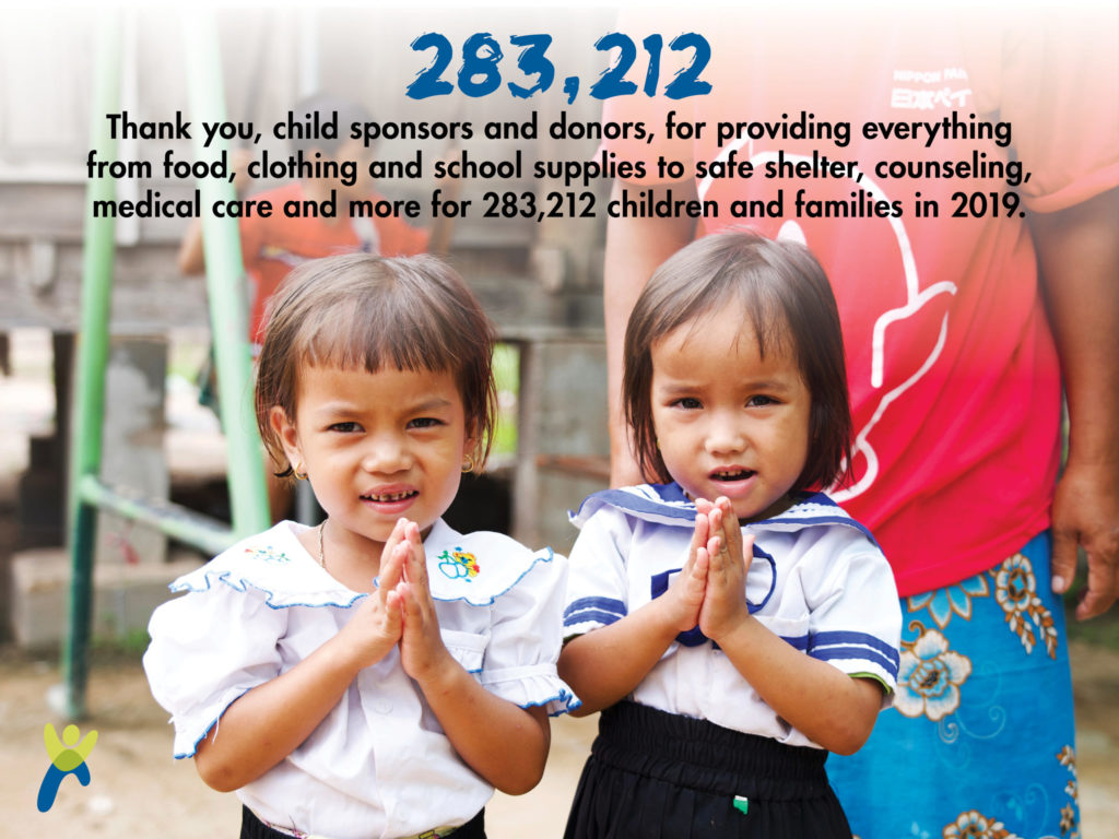 Two young gifts standing together with their hands together in prayer standing in front of an older child_graphic says 283,212 children and families were provided food clothing supplies medical care and more in 2019