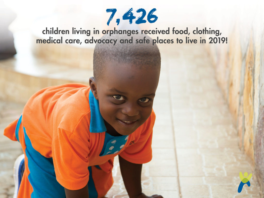 Child kneeling on floor looking up at camera and smiling_ graphic showing 7426 children in orphanages received food clothing medical care advocacy and safe places to live in 2019