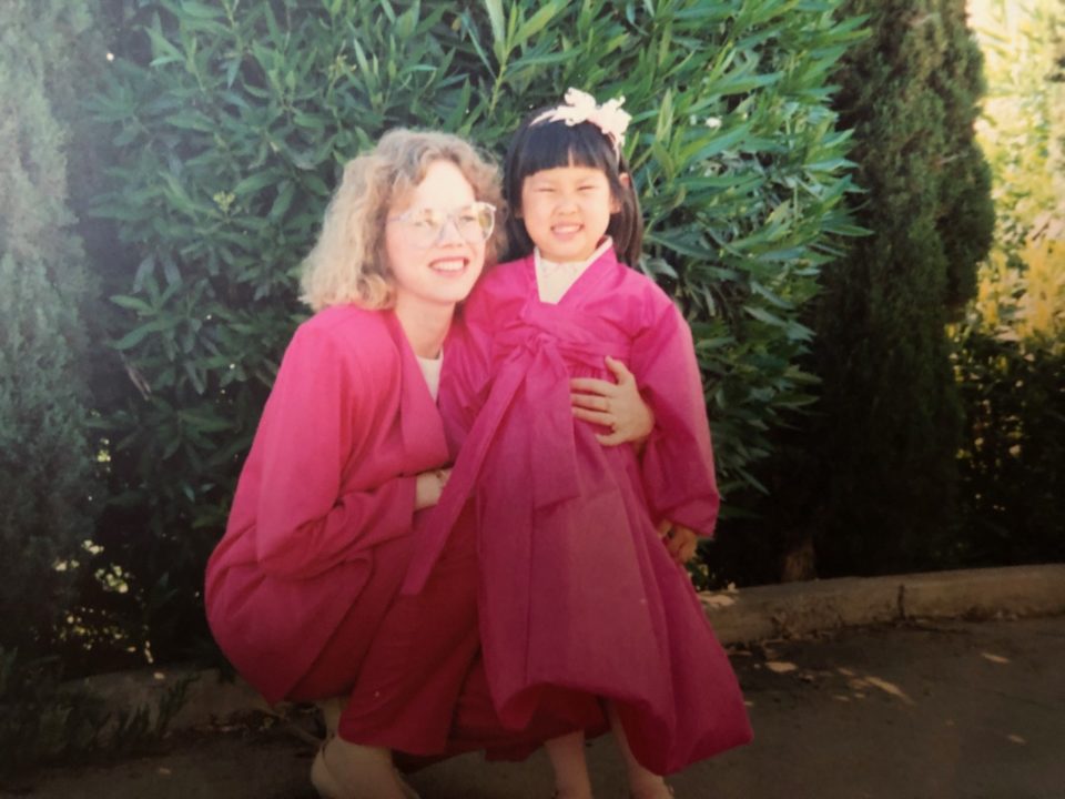 Lee as a little girl in a Korean handbook poses beside her mom.