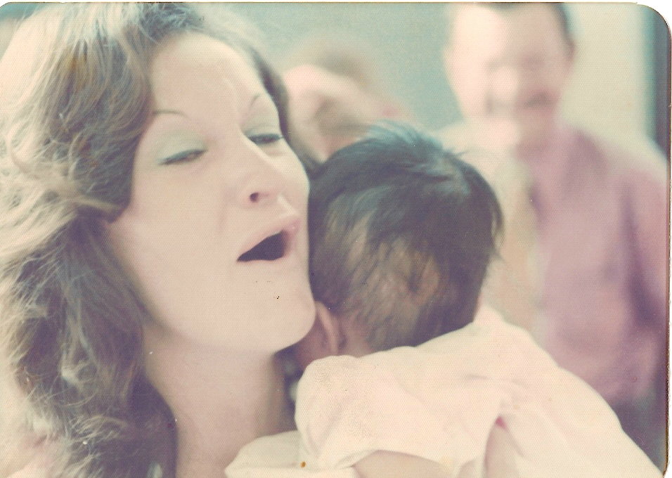 Tara's mom holding her as a baby. 