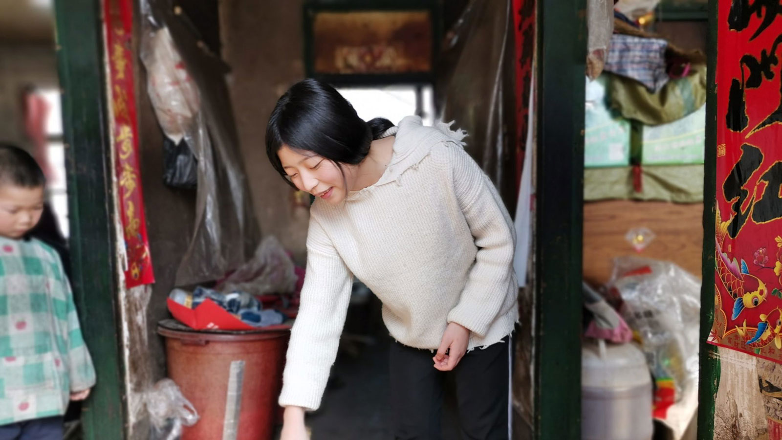 sponsored girl in China sweeping front steps