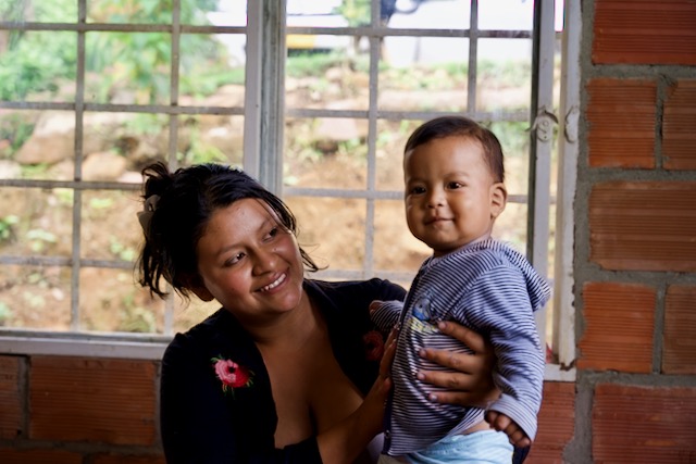 Diana holds her son in her lap. 