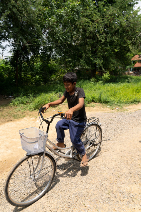 Kea rides the bicycle he received as a gift from a Holt donor. 