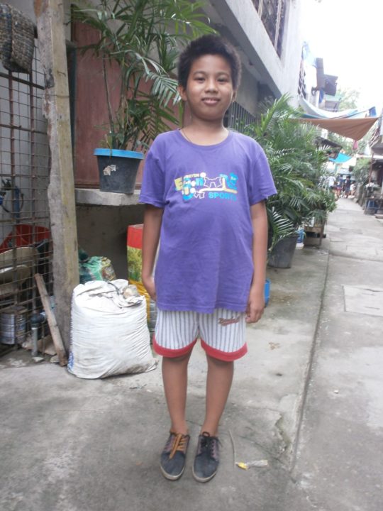 Danilos stands on a street near his home in the Philippines. 