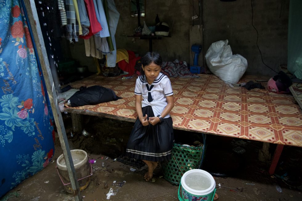 Linna sits on the raised platform where her family sleeps at night. 