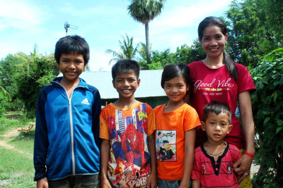woman and four children smiling at camera