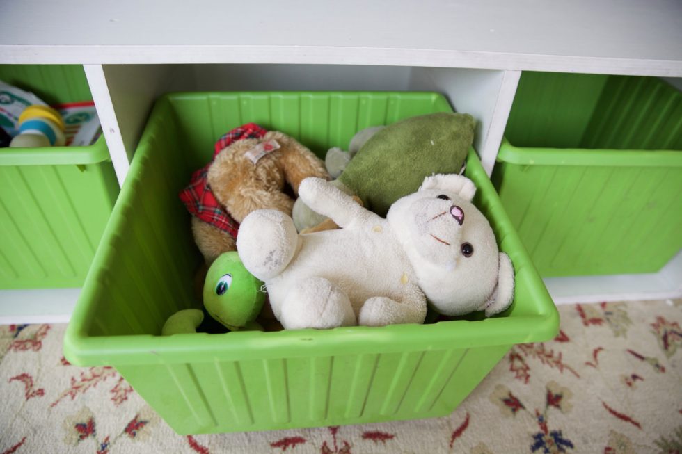 green plastic bin full of stuffed animals