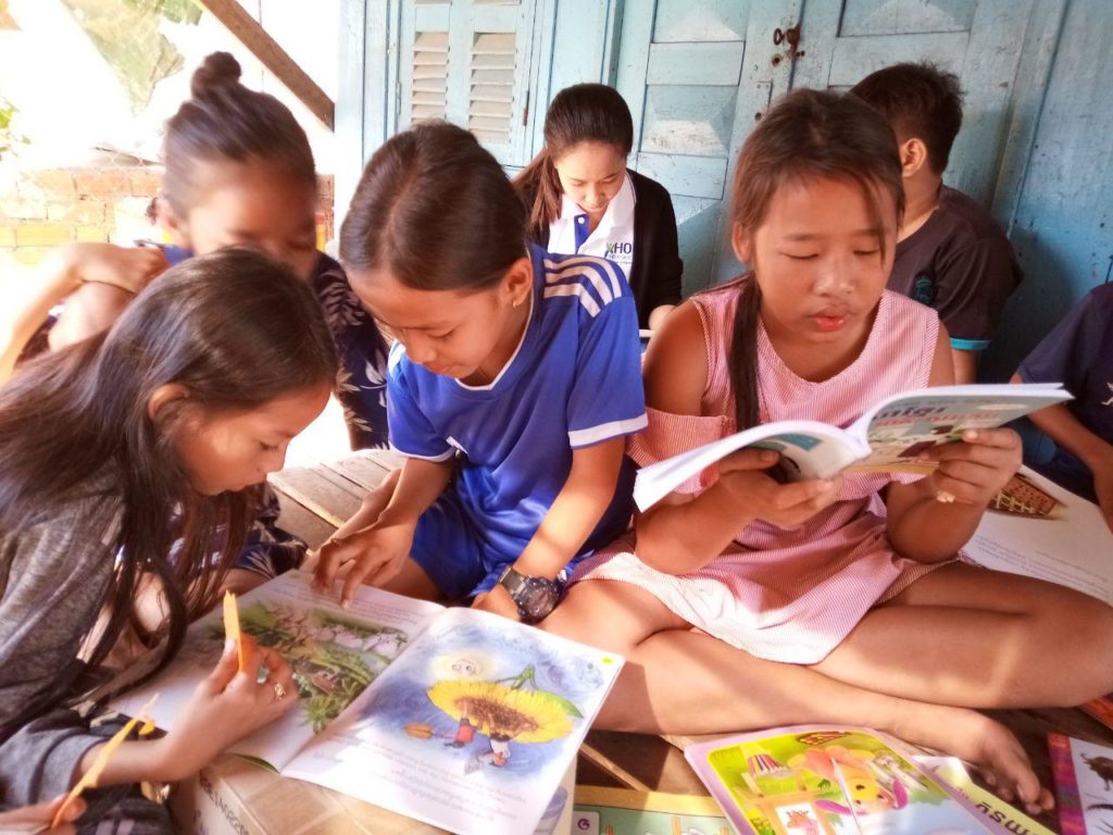 group of children looking at school workbooks