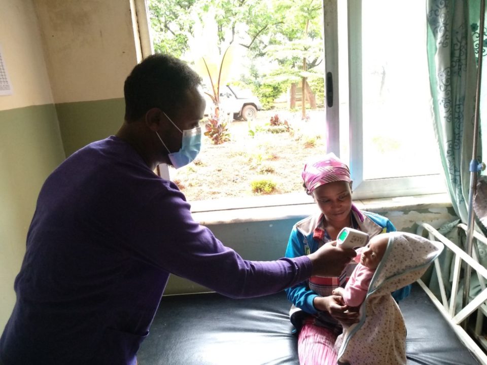 A doctor checks the temperature of a baby at the Shinshicho Mother & Child Hospital, which Holt donors helped build several years ago for the people of this impoverished community. To protect frontline workers and patients during the pandemic, Holt sponsors and donors helped provide supplies of masks, sanitizers and other PPE for the hospital.