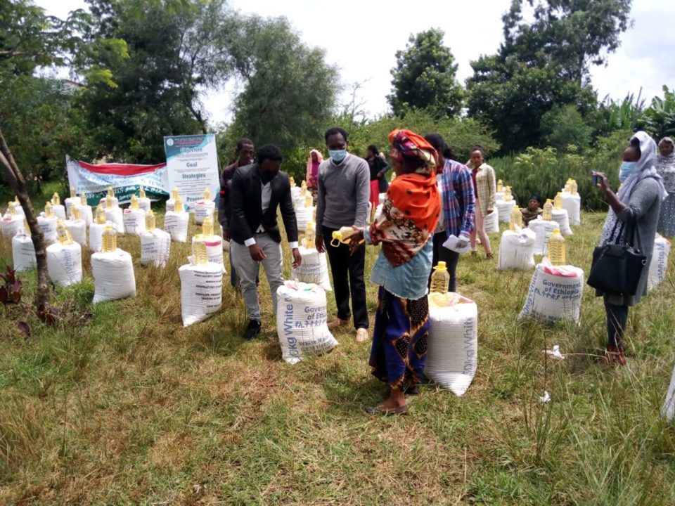 Holt staff distribute 5-liter bottles of cooking oil and bags of maize/corn, emergency food items that Holt donors provided for every family in sponsorship to help them survive the pandemic. 