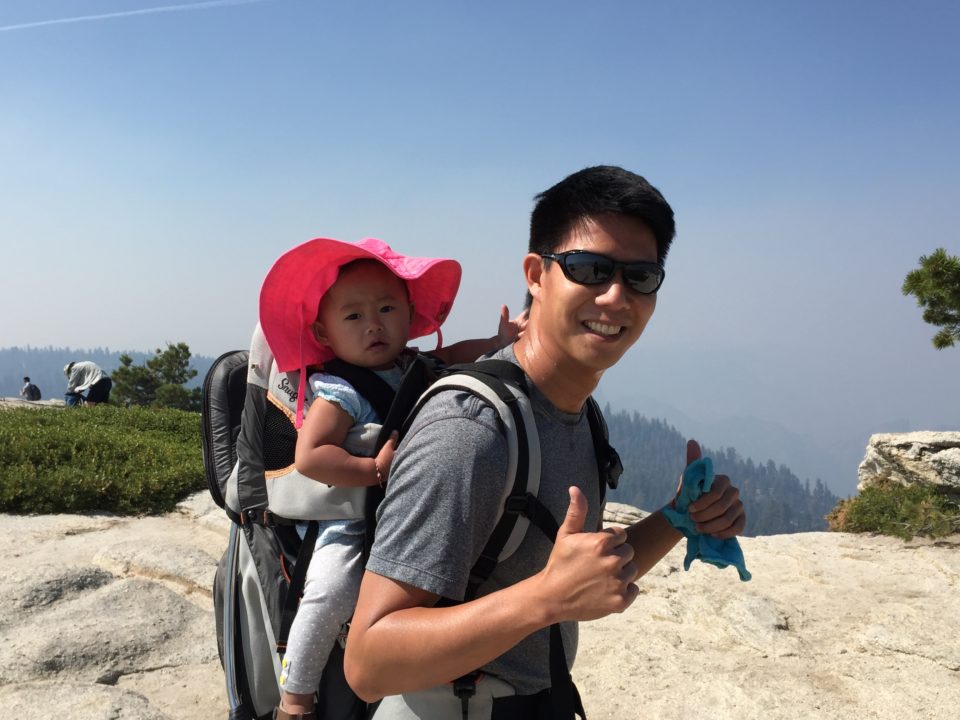 man carrying baby in harness