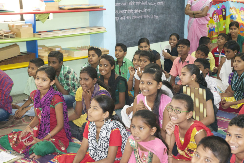 group of children sitting on the floor laughing at summer camp