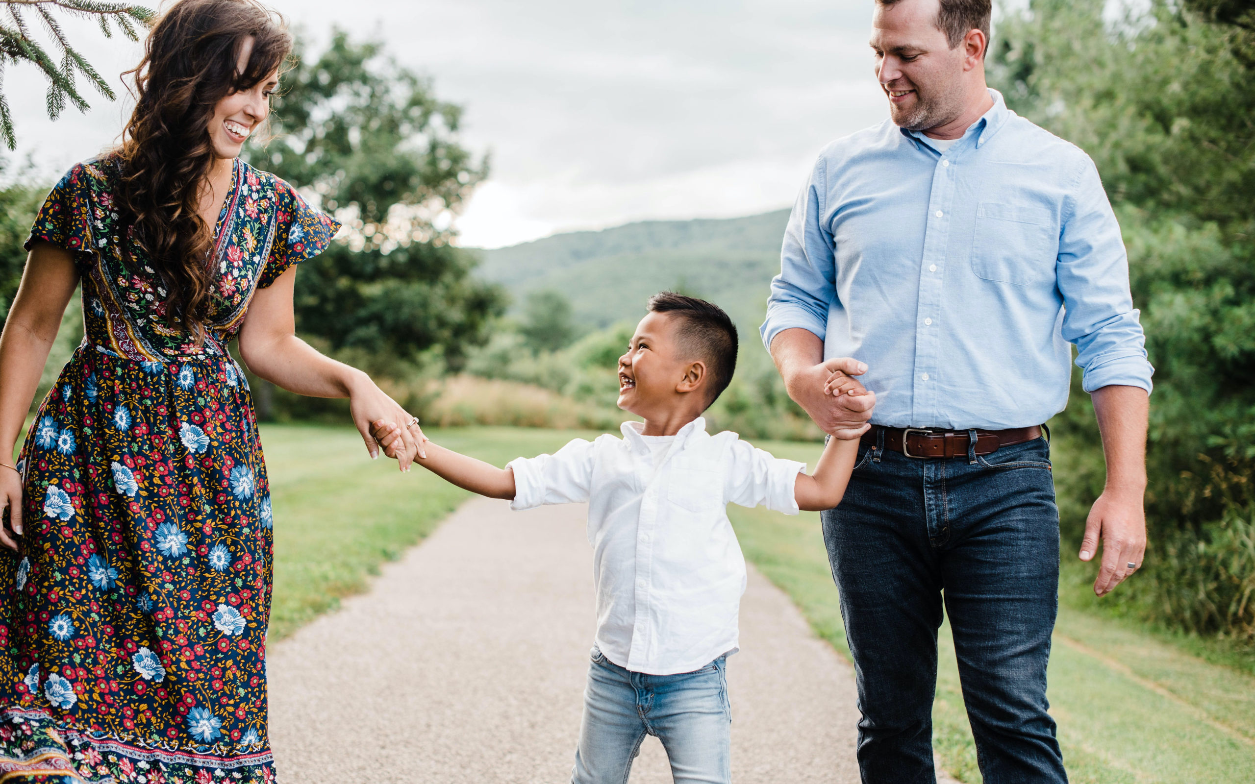 mom adoptive son and dad holding hands and laughing