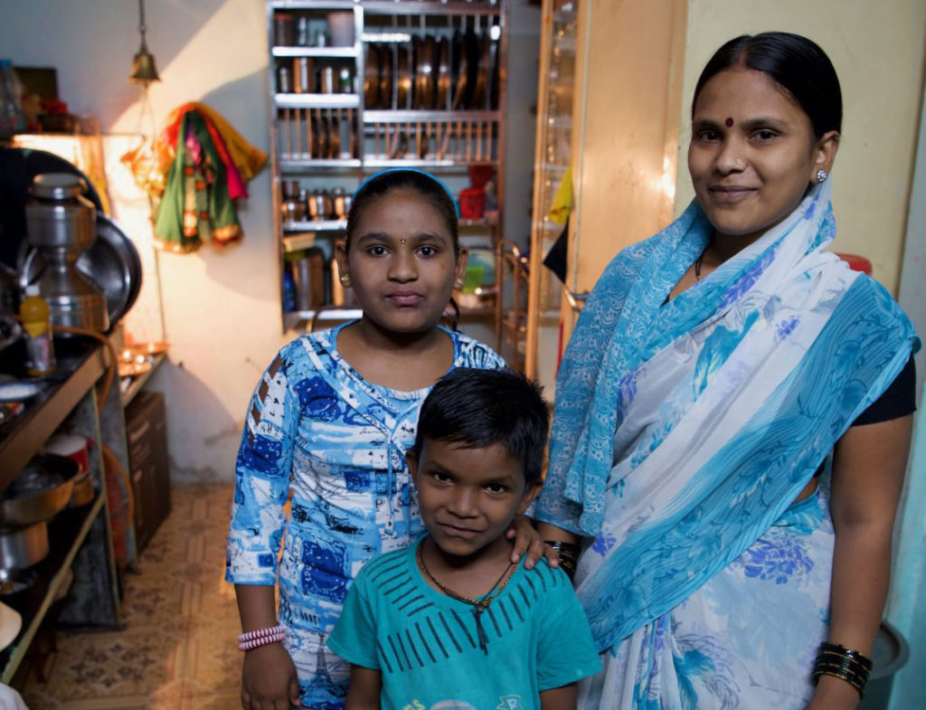 mother daughter and son standing looking at the camera in blue clothing