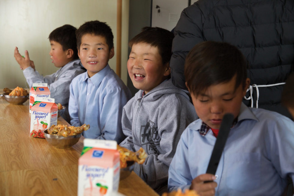 Children eat lunch at the Red Stone School in Mongolia — a special school for children who live in or near the city garbage dump. 