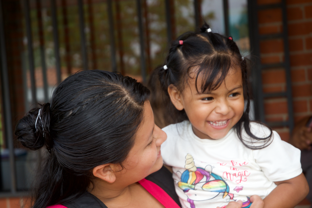 woman holding small girl laughing