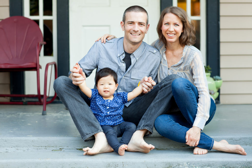 man and woman sitting on porch with baby