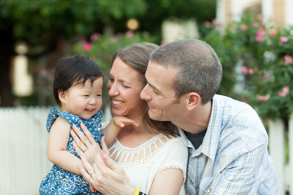 woman and man holding baby and smiling at baby