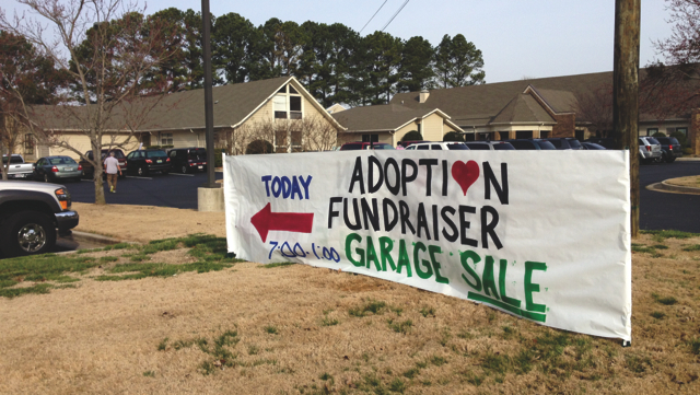 white banner that says "today adoption fundraiser garage sale"