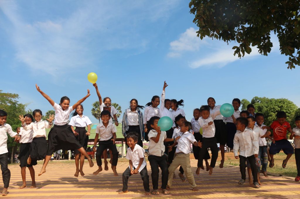 group of children jumping joyfully with colorful balloons