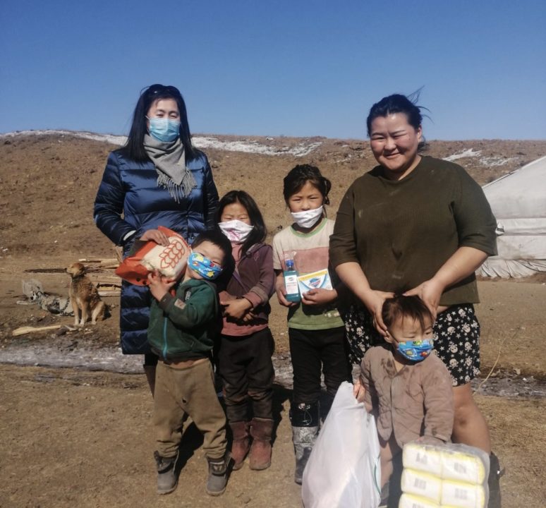 A Holt Mongolia staff member (left) distributes emergency food to a family living in the impoverished ger communities of Ulaanbaatar.