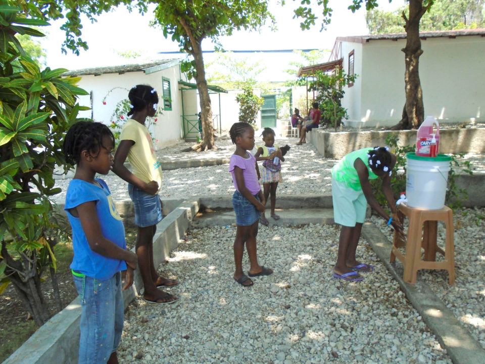 Children line up to wash their hands at hand-washing stations and sanitations kits Holt donated to five partner crèches in Haiti.