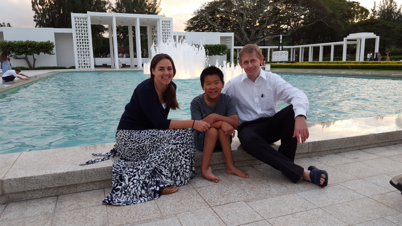 mom adopted son and dad sitting in front of family