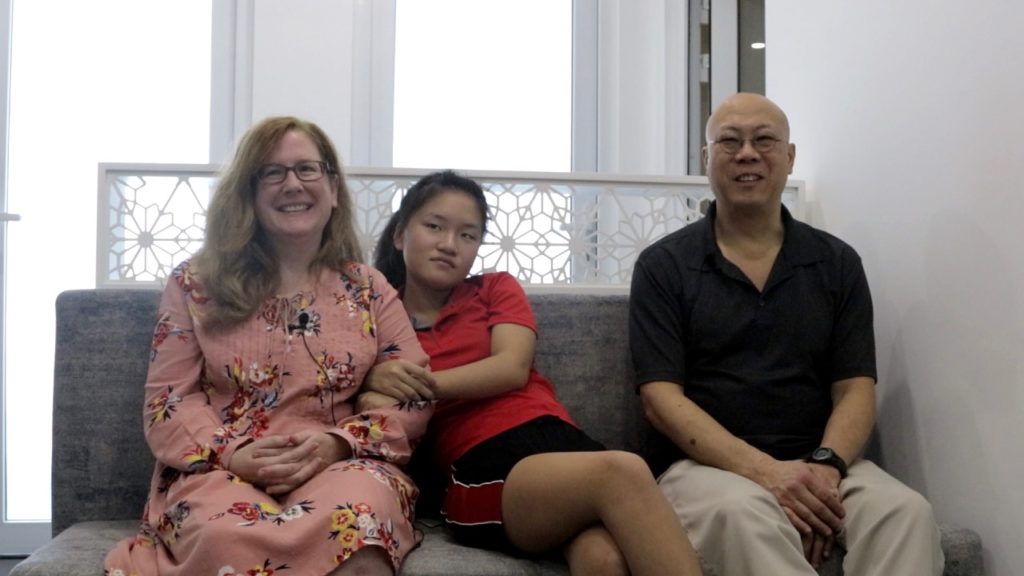 mom dad and daughter sitting on bench