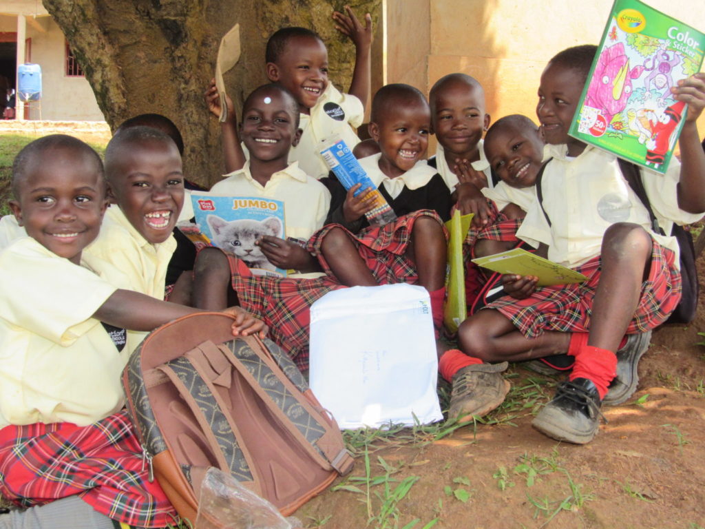 children sitting on the ground smiling