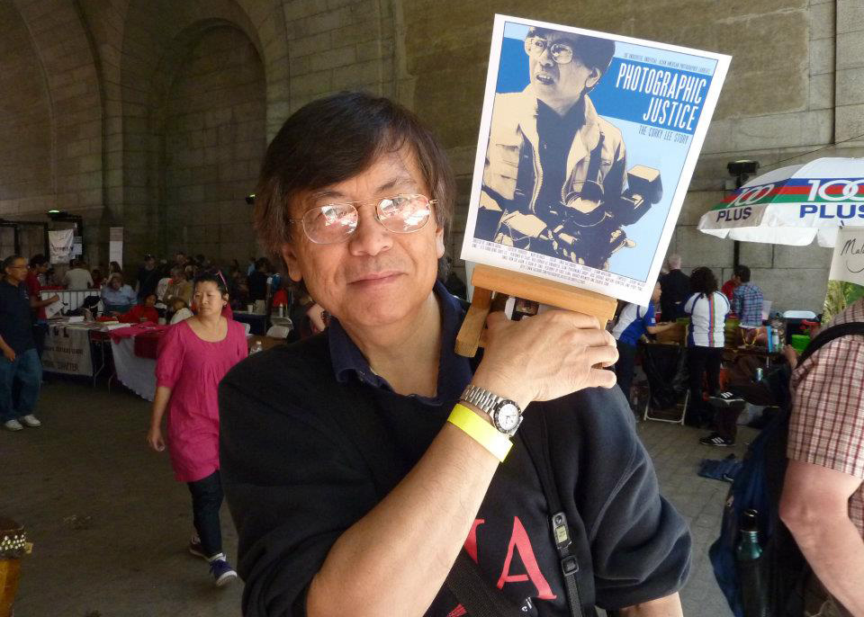 man holding up sign that says "photographic justice"