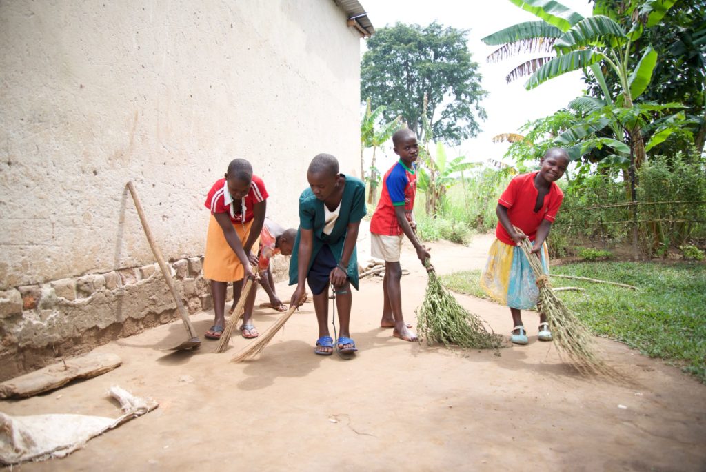 four children sweeping