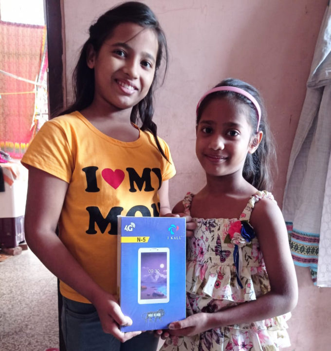 Two girls hold a tablet they received through the generous support of Holt sponsors and donors. All sponsored children received tablets (laptops) to attend school remotely throughout the pandemic. 