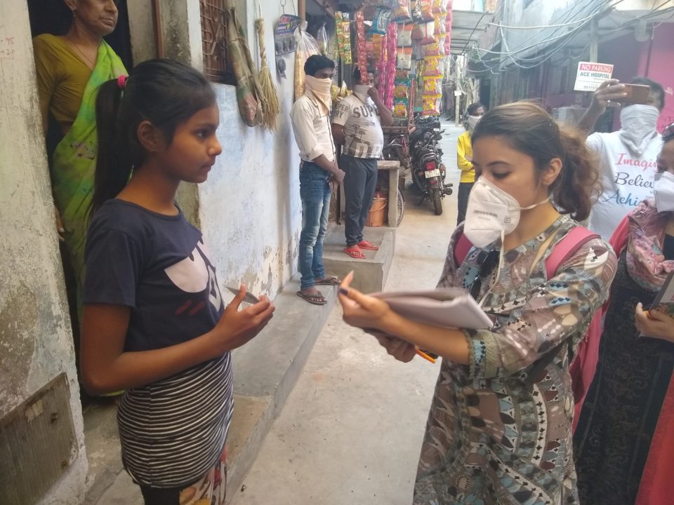 Masked to prevent the spread of COVID, a local team member meets with sponsored children and families in Delhi.