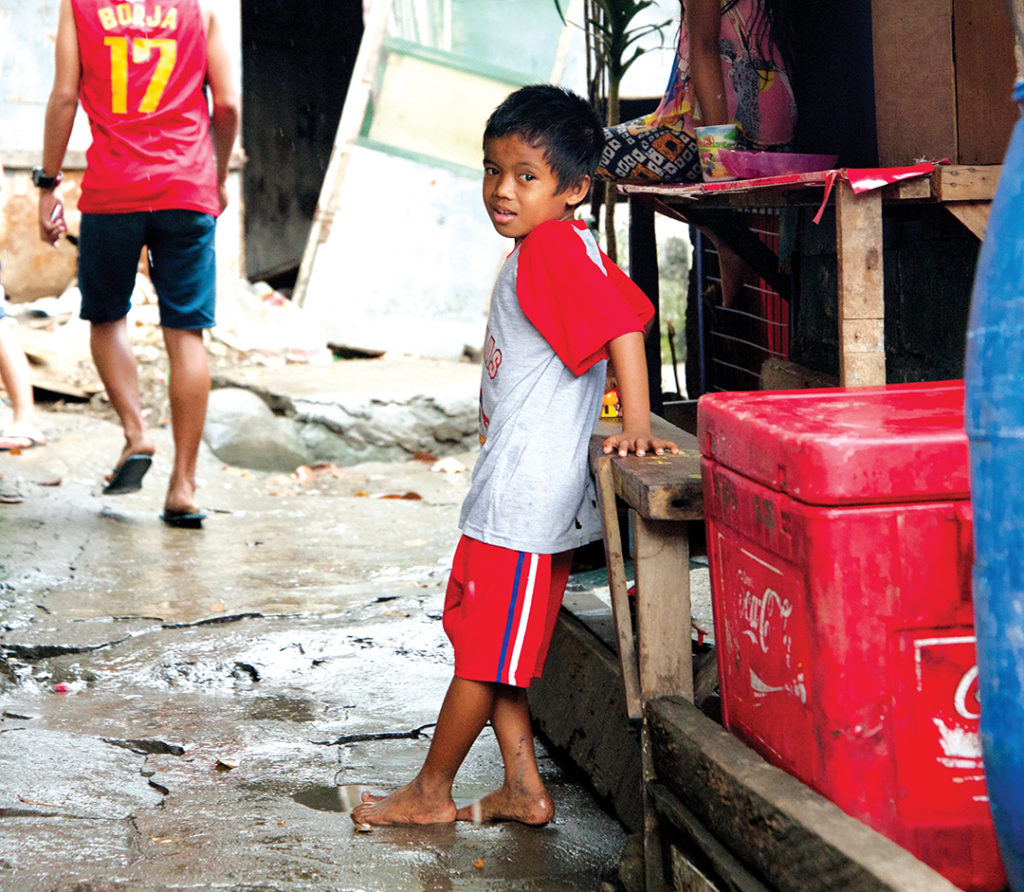 child standing in the street looking at the camera