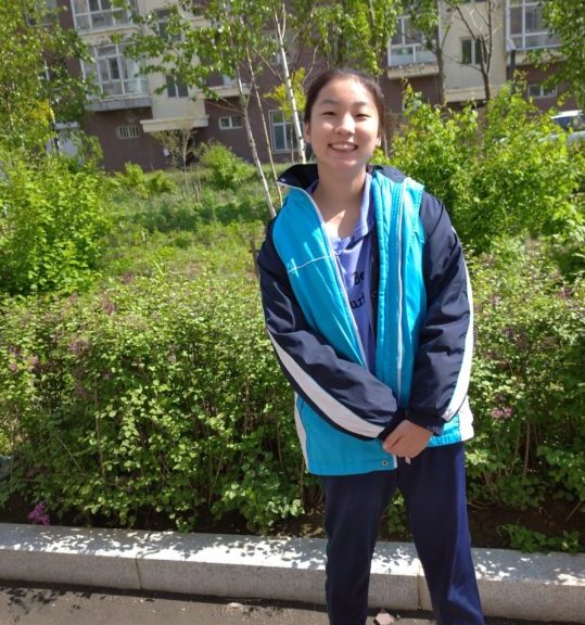 Girl smiling in front of building