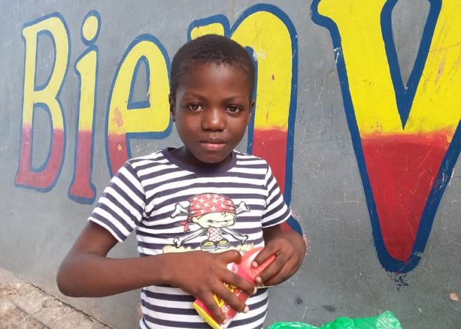 boy in front of wall after earthquake in Haiti 