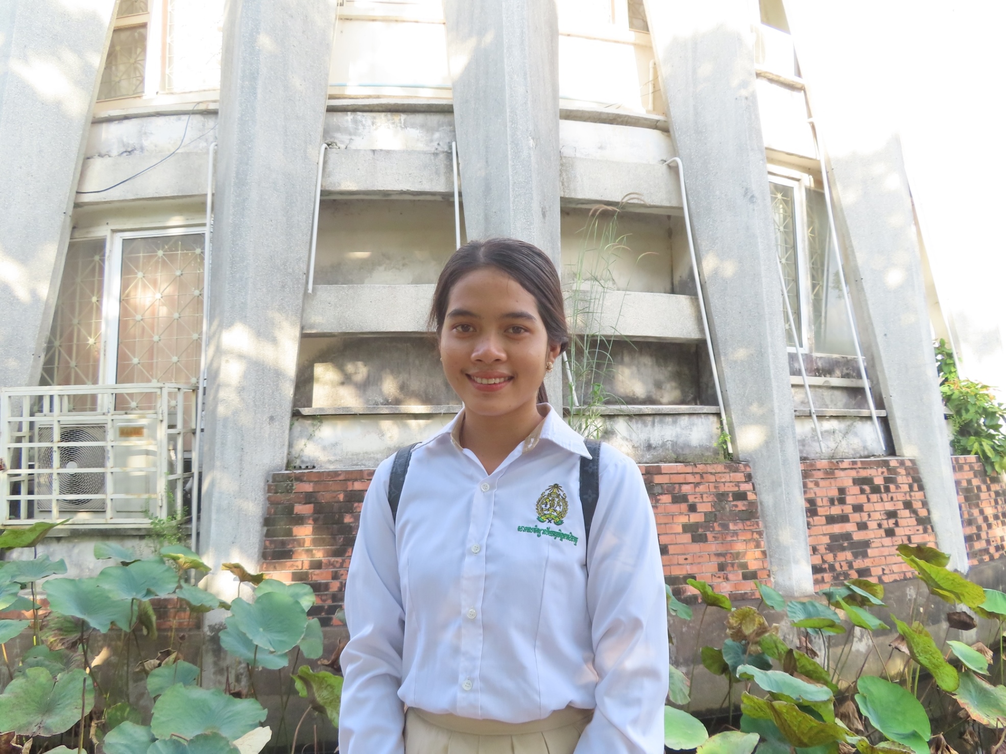 girl in university uniform smiling at camera