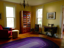 room with brown wooden bookshelf desk and purple oval rug