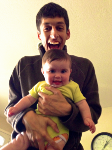 smiling man holding laughing baby
