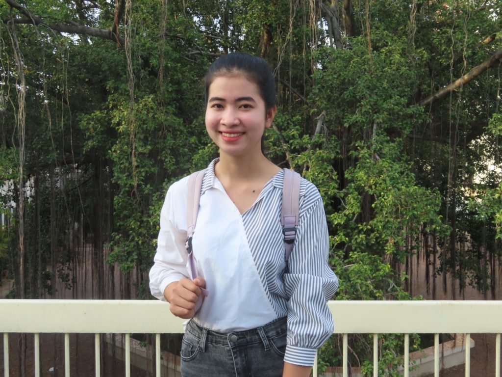 girl with pink backpack smiling at camera