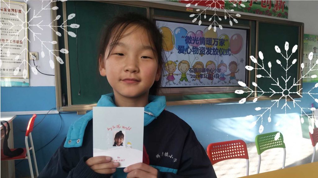 Little girl in China holding her Christmas ornament
