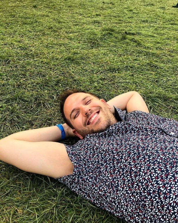 smiling man laying in the grass