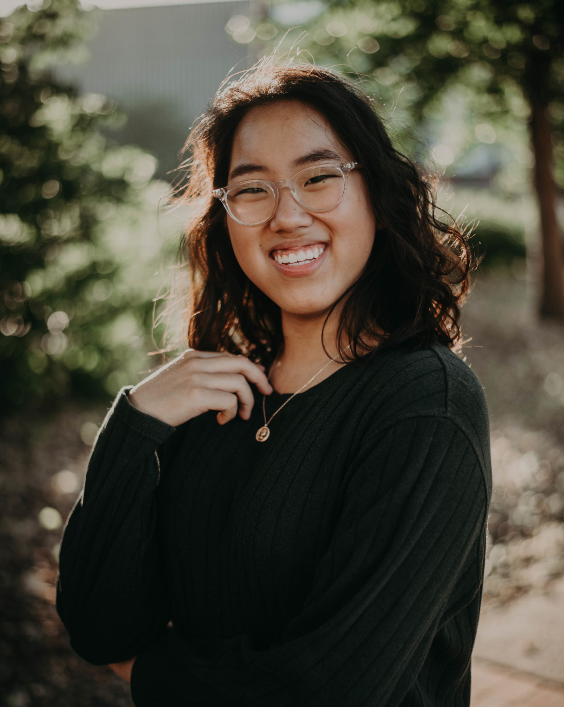 smiling girl wearing sweater and clear glasses